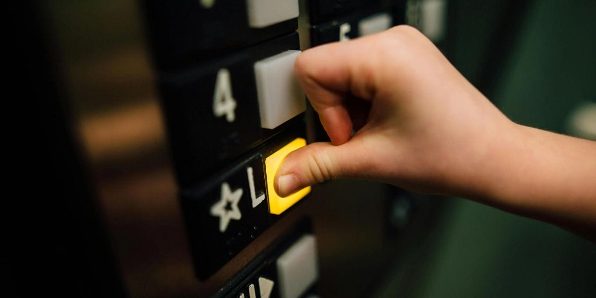Someone pushing a button in a lift